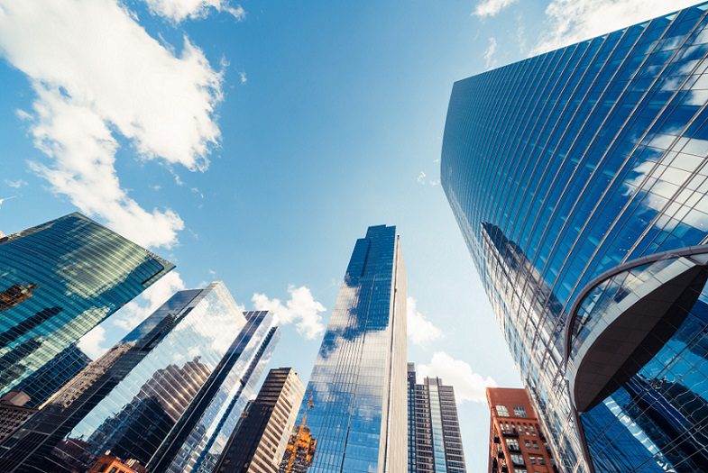 בנייני מגדל מודרניים או גורדי שחקים ברובע פיננסי עם ענן ביום שמש בשיקגו, ארה"ב