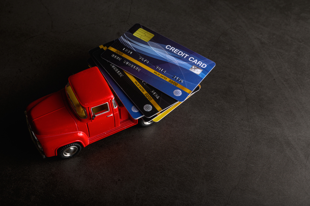צילום תקריב של כרטיסי אשראי על גבי צעצוע של משאית מיובאת