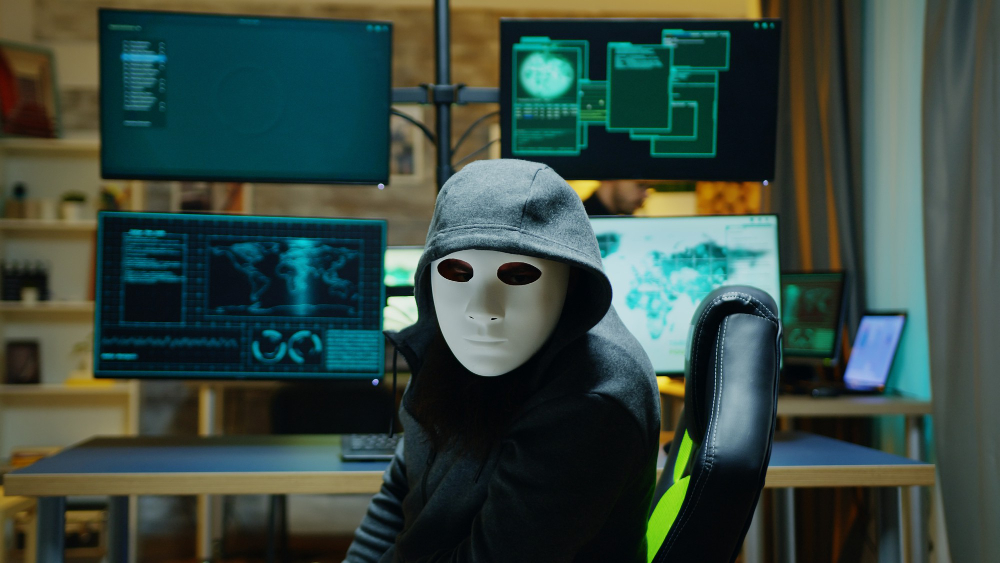 האקר לובש מסיכה וכובע שחור כדי להחביא את זהותו בפשיעה אינטרנטית