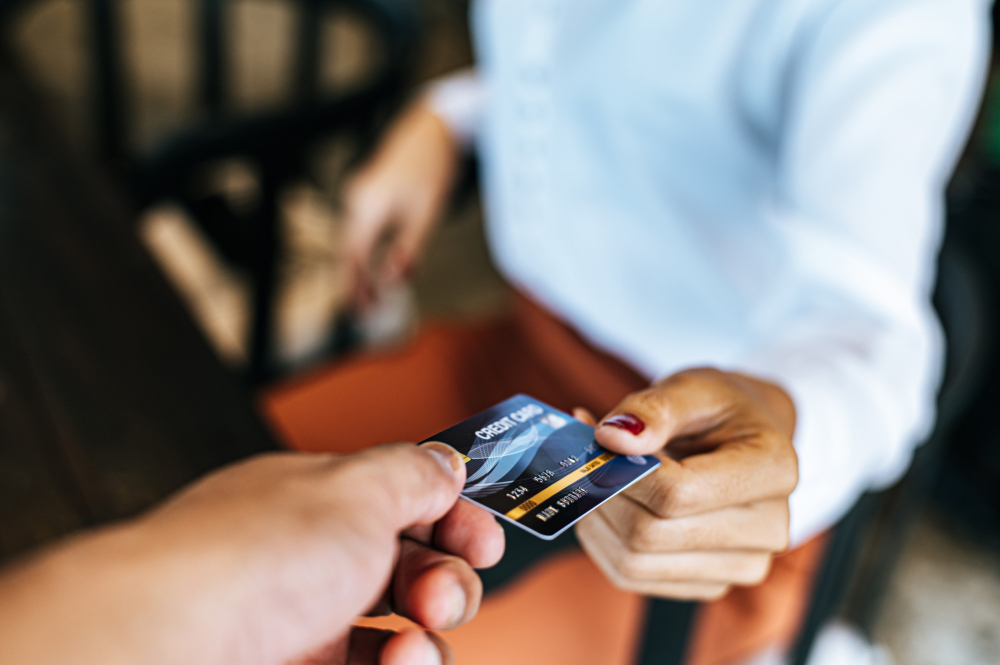 קונספט חוק אשראי הוגן תצלום תקריב של אישה שמביאה את כרטיס האשראי שלה לרכישה של מוצרים