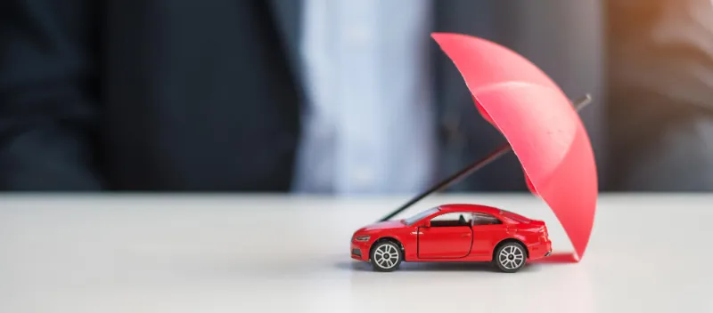 מטריה אדומה המכסה מכונית צעצוע קונספט כיסוי ביטוח רכב