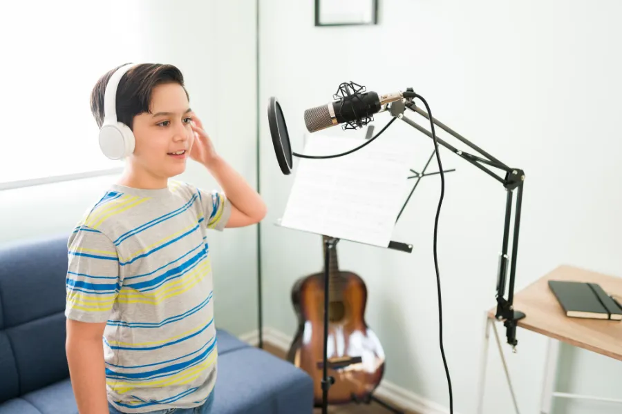 ילד כשרוני שר במיקרופון באולפן