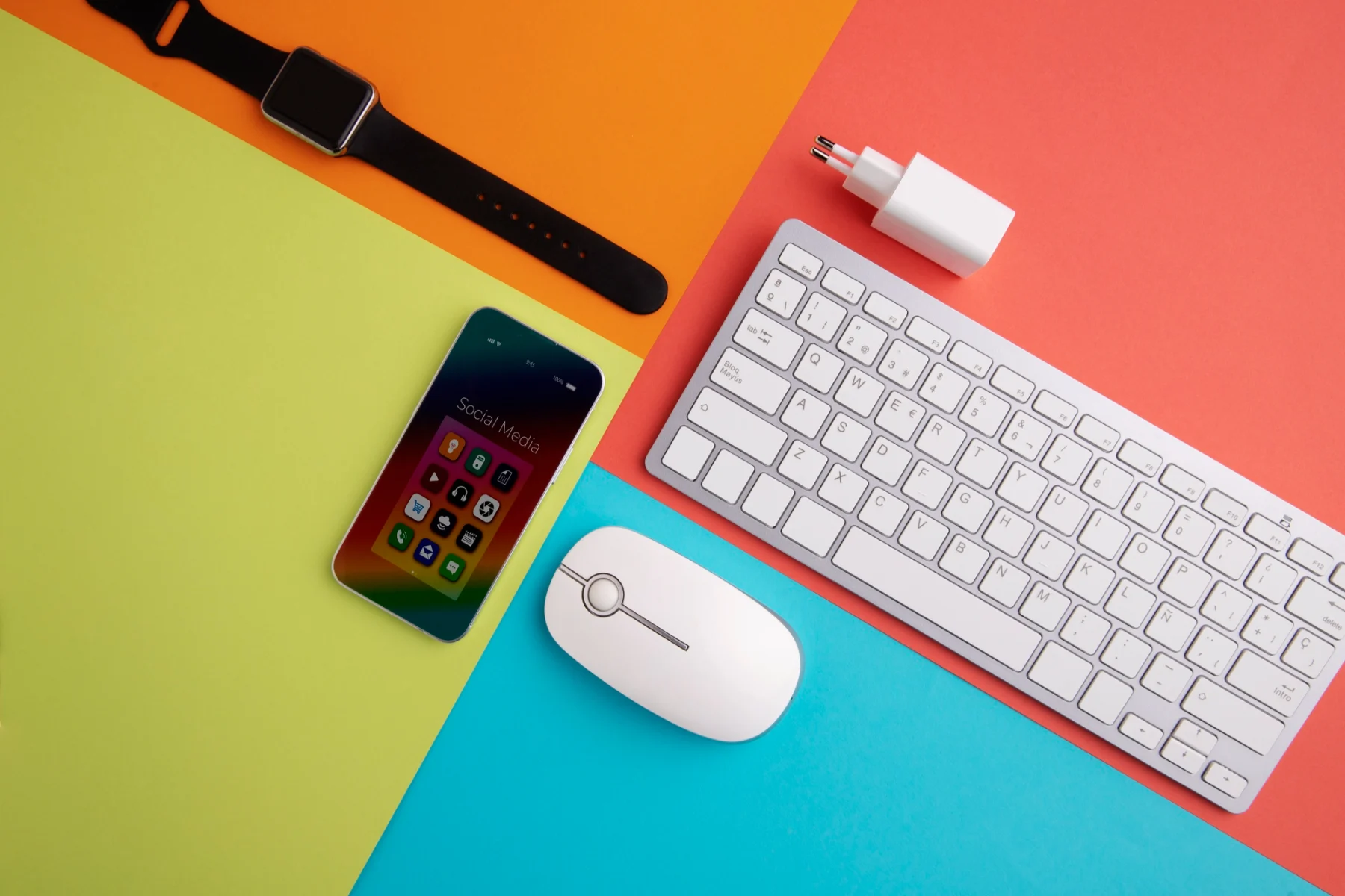 מוצרי אפל מקלדת עכבר מטען אייפון ושעון חכם ברקע צבעוני וסימטרי